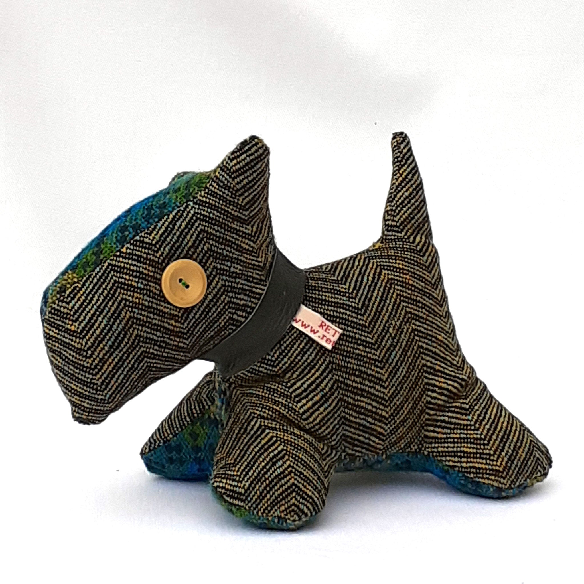 Close up of handmade tweed fabric Scottie dog.  Made from brown chevron tweed with bright blue and green tweed accent head and stomach panels.. ReTweed label on collar, and a beige button eye.