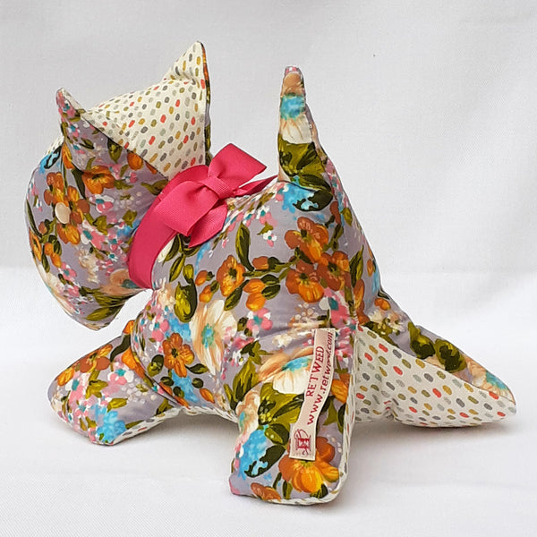Rear view of handmade Scottie Dog with floral pattern fabric with pink bow. Spotty head and underside with a ReTweed label.