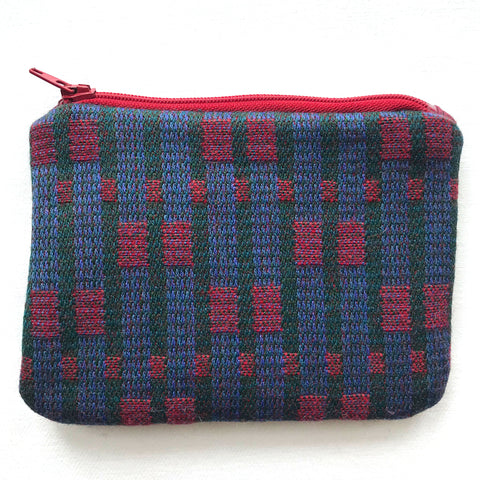 Close up of blue and red tweed fabric purse with a red zip