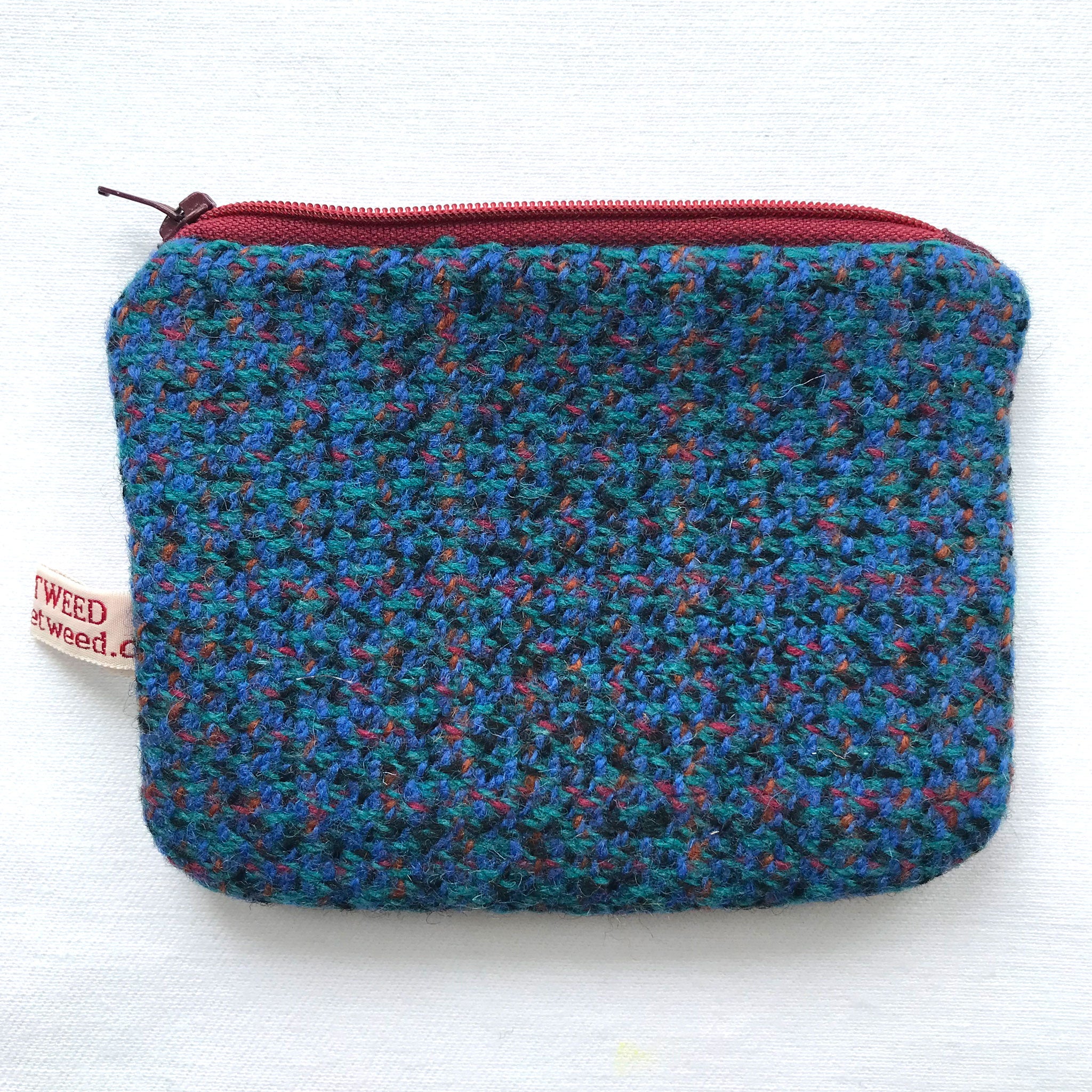 Close up of blue tweed purse with red and green dots and red zip. ReTweed label is showing.