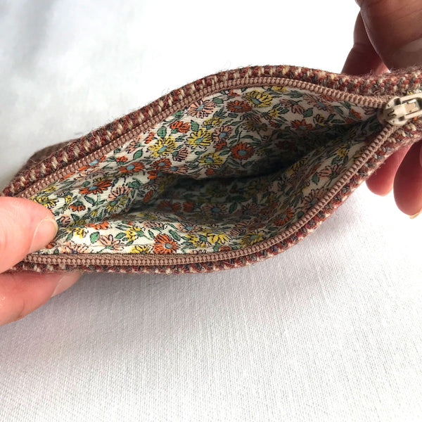 Inside red tweed purse with beige zip and floral fabric in green, yellow and red