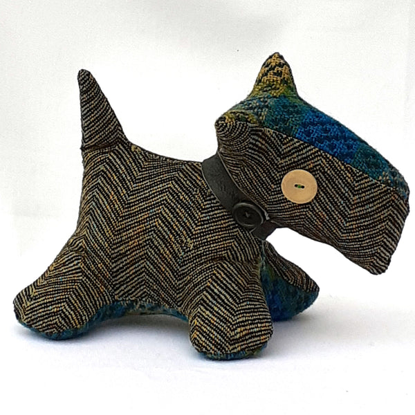 Side view of handmade tweed fabric Scottie dog.  Made from brown chevron tweed with bright blue and green tweed accent head and stomach panels.. Brown collar and beige button eye.