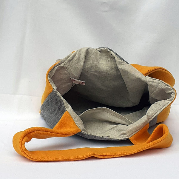The inside of bag with beige fabric lining
