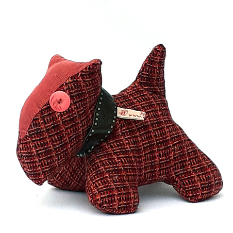 Close up of soft toy scottie dog, with red tweed fabric, and pink corduroy nose and collar 