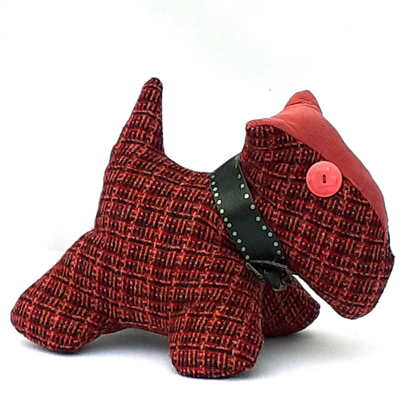 Close up of soft toy scottie dog, with red tweed fabric, and pink corduroy nose and collar 